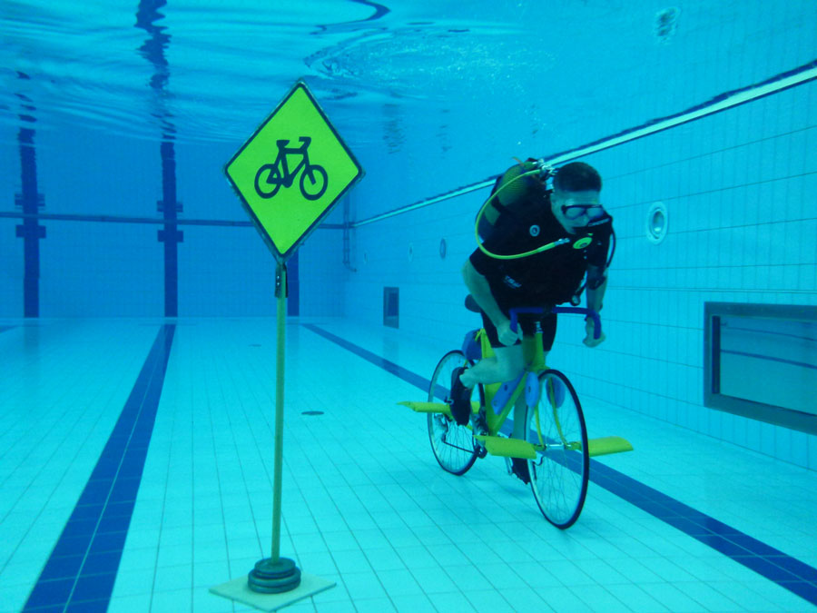 Ashrita Furman setting the record for longest distance to bicycle underwater (1.88 m/3.03 km) in September 2011. Photograph by Homagni Batista distributed under a CC BY-SA 3.0 license.