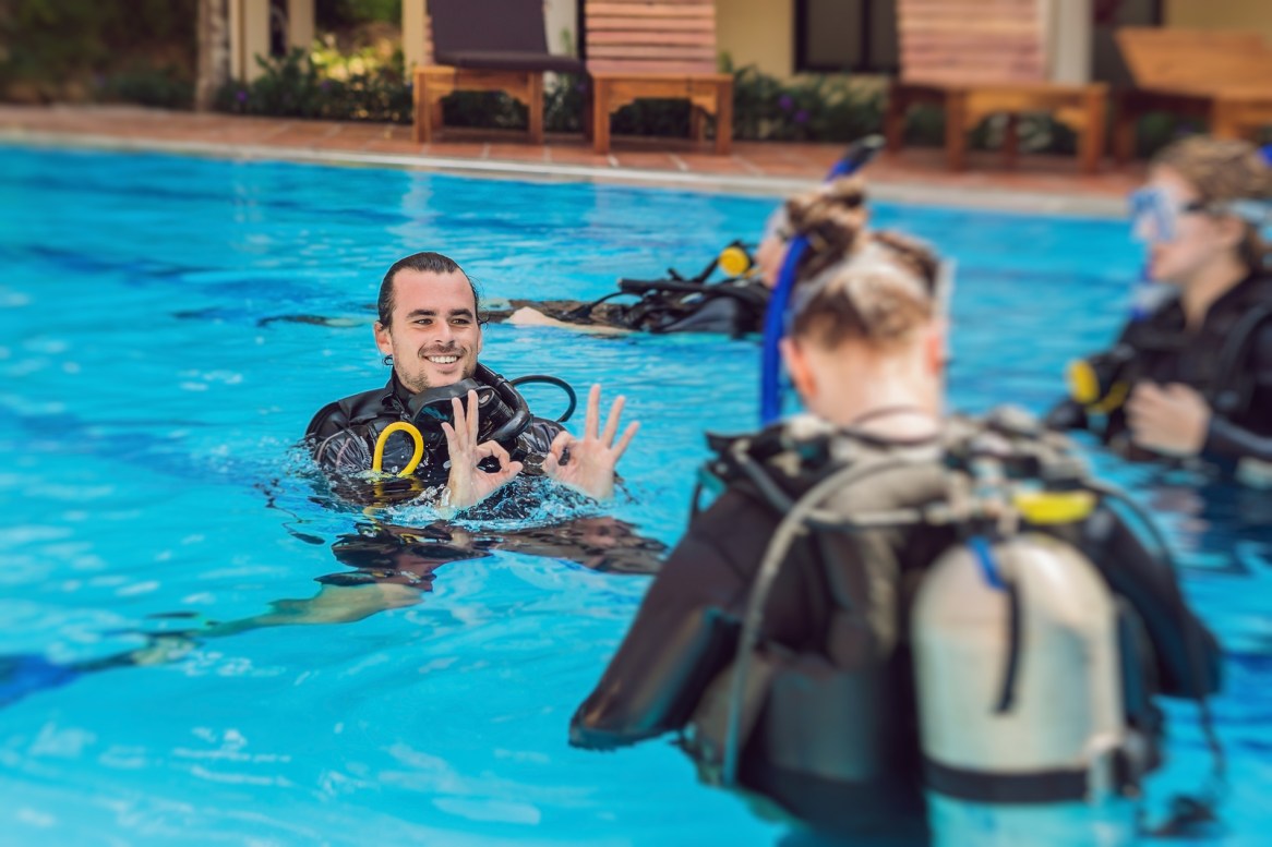 Diving Instructor And Students. Instructor Teaches Students To D